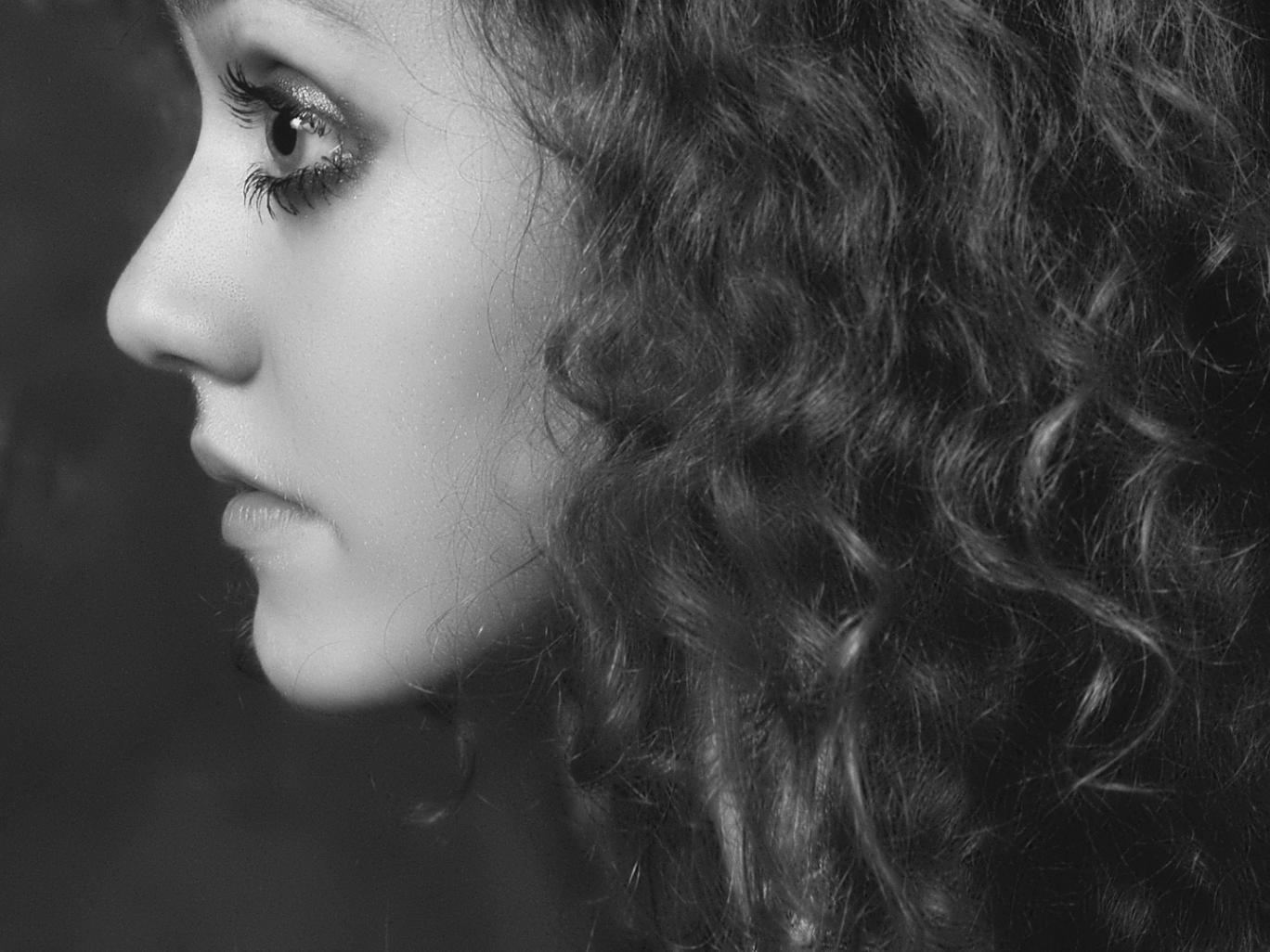 Donna con capelli ricci naturali curati con trattamento professionale